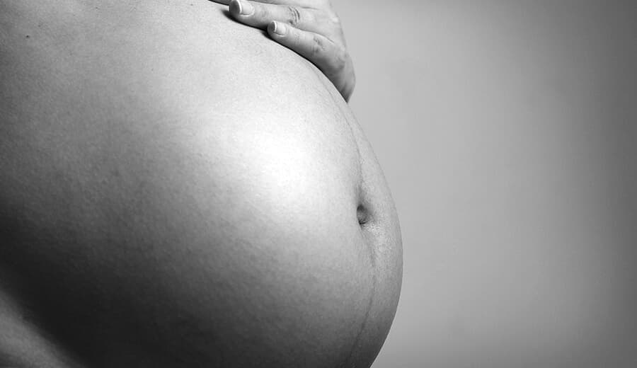 black and white photo of pregnant woman's stomach