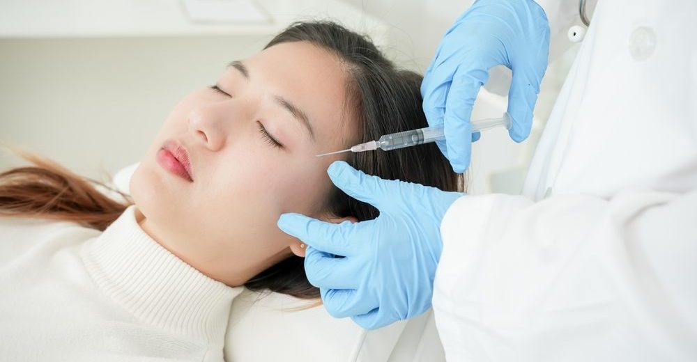 Woman receiving dermal filler injection in clinical setting for facial rejuvenation