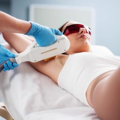 Woman receiving underarm laser hair removal treatment during a professional session